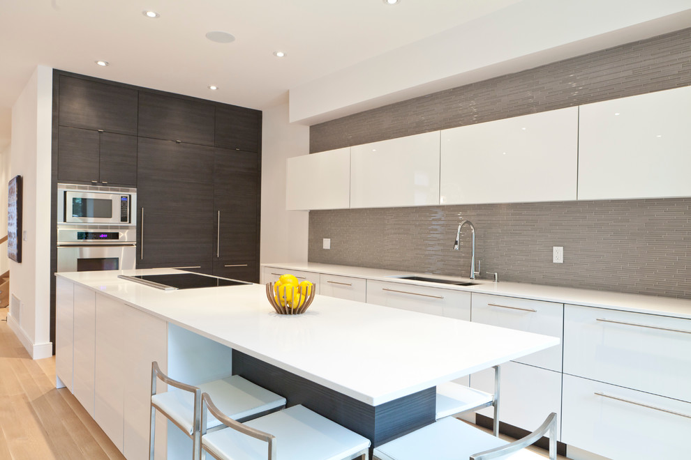 Imagen de cocina minimalista con electrodomésticos con paneles y barras de cocina