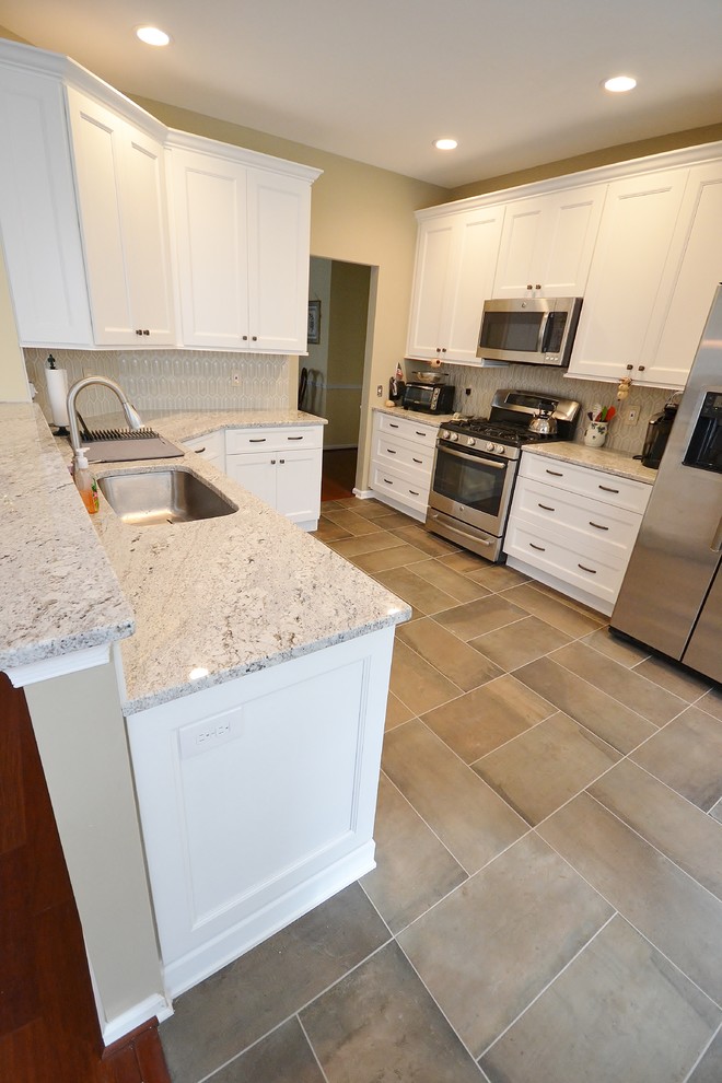 Mid-sized transitional l-shaped ceramic tile eat-in kitchen photo in Philadelphia with an undermount sink, recessed-panel cabinets, white cabinets, granite countertops, beige backsplash, mosaic tile backsplash, stainless steel appliances and no island