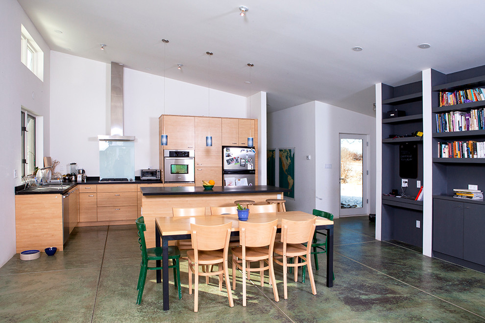 Foto di una cucina design con ante lisce, ante in legno scuro, paraspruzzi bianco, paraspruzzi con lastra di vetro e elettrodomestici in acciaio inossidabile