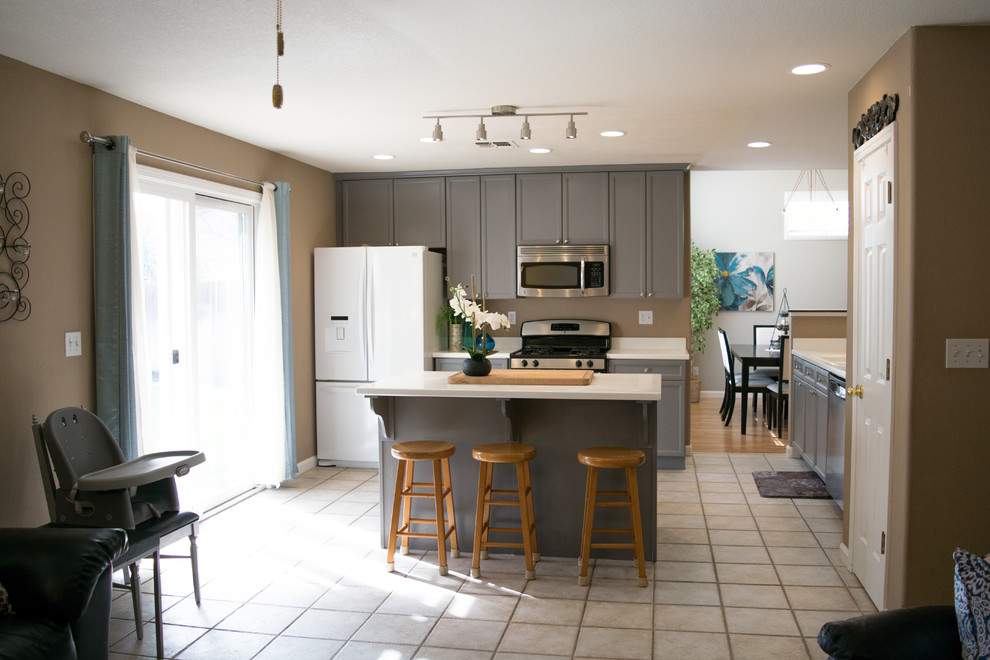 Foto di una piccola cucina tradizionale con ante in stile shaker, ante grigie, elettrodomestici in acciaio inossidabile, pavimento bianco, lavello integrato e paraspruzzi bianco