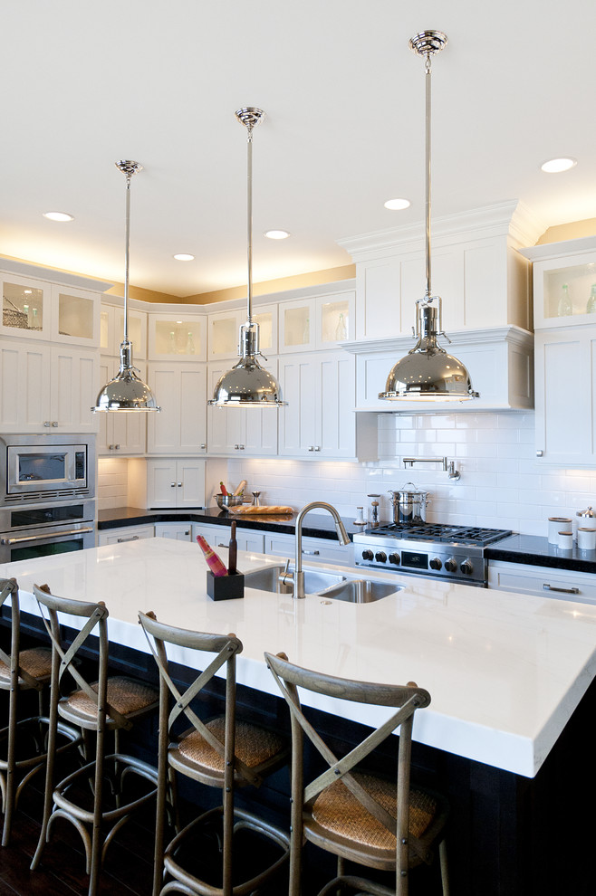 Photo of a large traditional l-shaped kitchen in Salt Lake City with stainless steel appliances, metro tiled splashback, a submerged sink, shaker cabinets, dark wood cabinets, marble worktops, white splashback and an island.