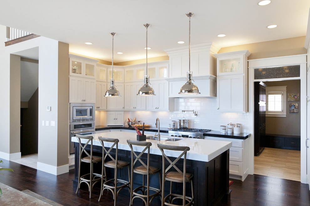 Inspiration for a large coastal l-shaped dark wood floor eat-in kitchen remodel in Salt Lake City with an undermount sink, recessed-panel cabinets, white cabinets, marble countertops, white backsplash, stainless steel appliances, an island and subway tile backsplash