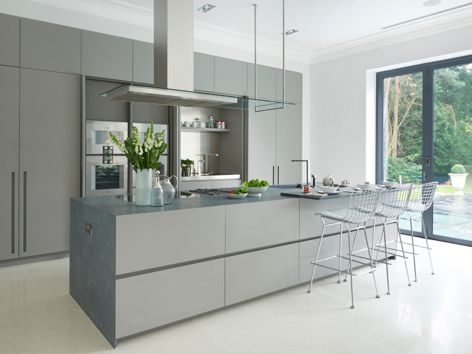 Design ideas for an expansive contemporary open plan kitchen in London with an integrated sink, flat-panel cabinets, grey cabinets, metal splashback, stainless steel appliances and an island.