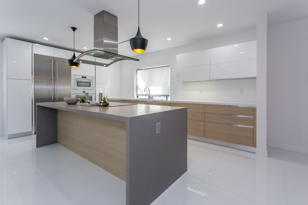 Example of a huge minimalist single-wall porcelain tile eat-in kitchen design in Los Angeles with white cabinets, quartz countertops, stainless steel appliances and an island