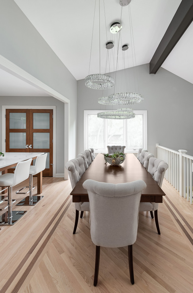 Cette image montre une salle à manger ouverte sur le salon traditionnelle de taille moyenne avec parquet clair et un sol marron.