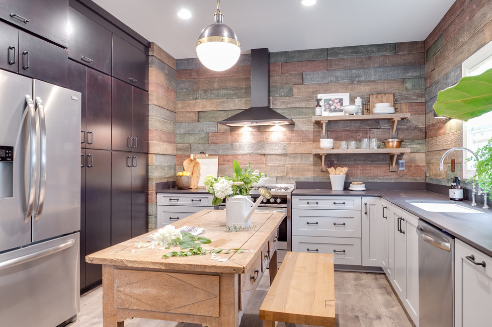 Inspiration for a mid-sized transitional u-shaped light wood floor enclosed kitchen remodel in Seattle with an undermount sink, flat-panel cabinets, dark wood cabinets, concrete countertops, wood backsplash, stainless steel appliances and an island