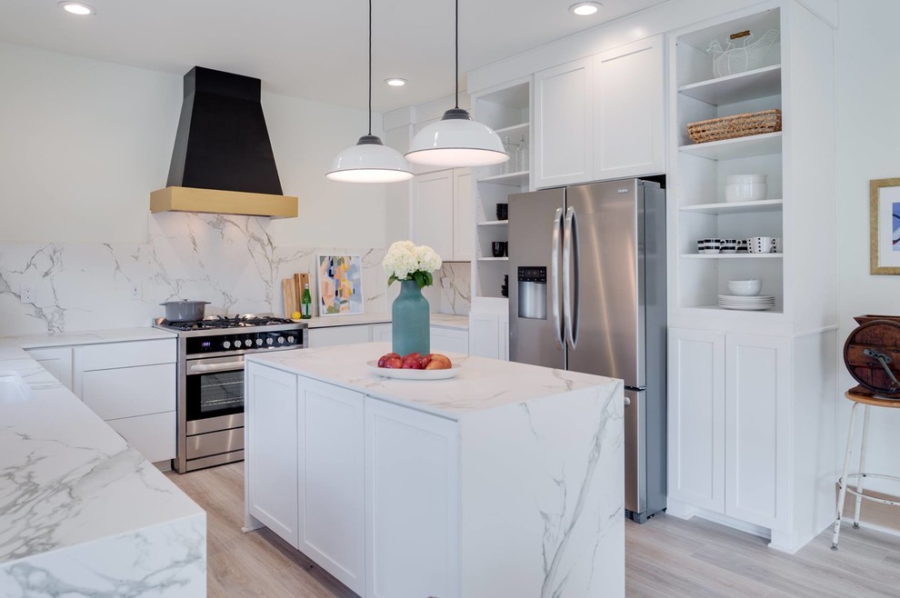 Photo of a large scandi u-shaped open plan kitchen in Calgary with a submerged sink, shaker cabinets, white cabinets, marble worktops, white splashback, marble splashback, stainless steel appliances, light hardwood flooring, an island and grey floors.