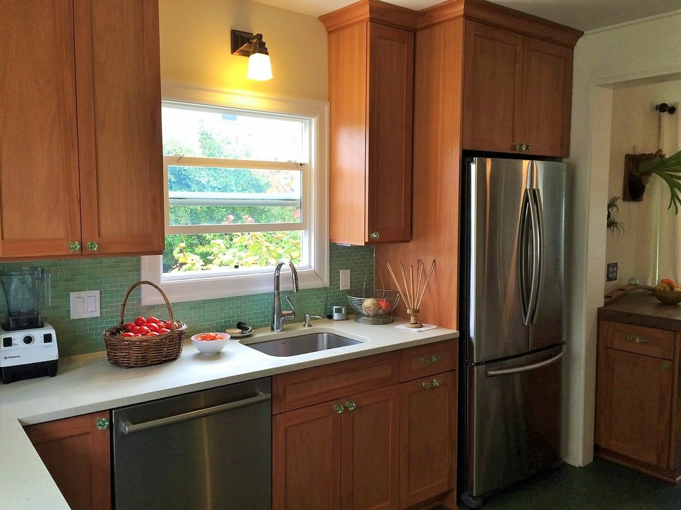 Bild på ett litet vintage vit vitt kök, med en undermonterad diskho, släta luckor, skåp i mellenmörkt trä, grönt stänkskydd, stänkskydd i glaskakel, rostfria vitvaror, linoleumgolv, bänkskiva i kvartsit och grönt golv