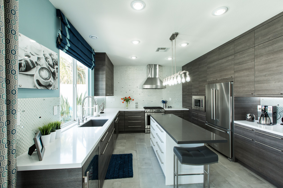 Example of a large minimalist u-shaped eat-in kitchen design in Las Vegas with flat-panel cabinets, gray cabinets, quartzite countertops, gray backsplash, glass tile backsplash, stainless steel appliances and an island