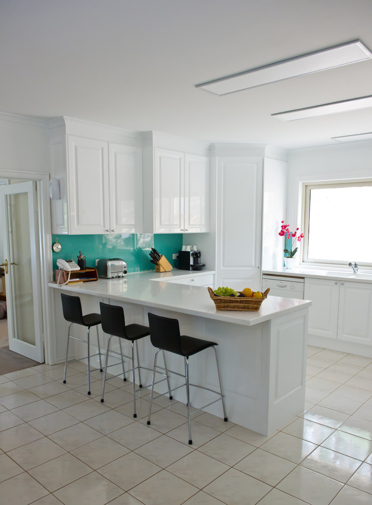 Immagine di una cucina minimal con lavello integrato, top in superficie solida e paraspruzzi con lastra di vetro