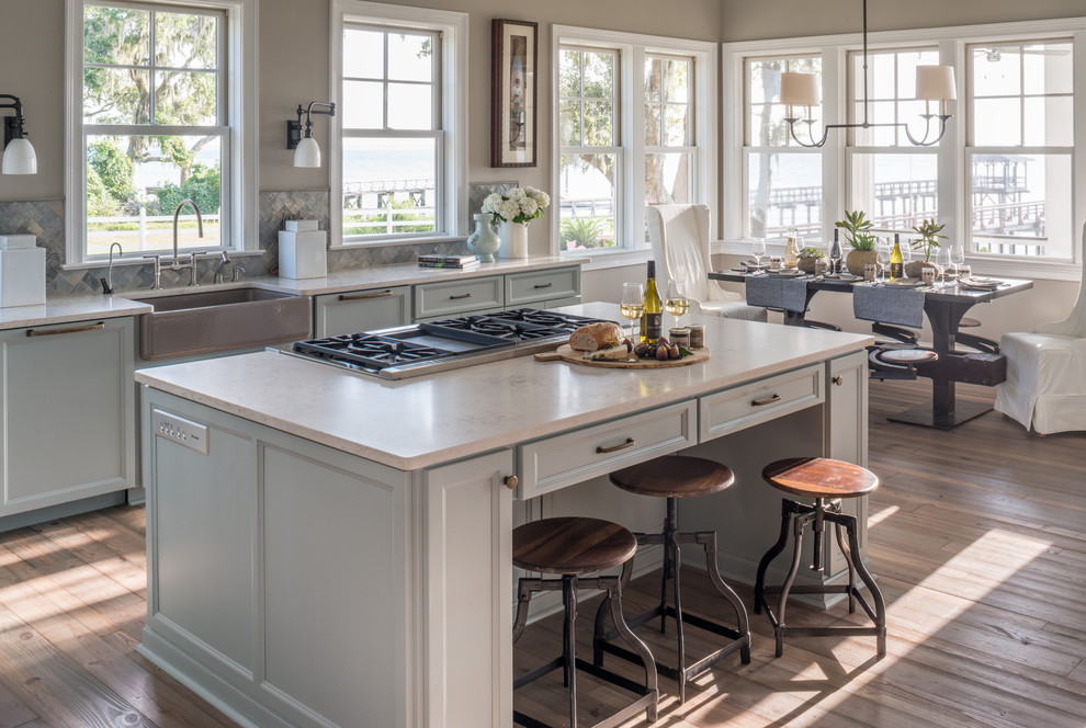Eat-in kitchen - large traditional light wood floor eat-in kitchen idea in Milwaukee with a farmhouse sink, white cabinets, marble countertops, beige backsplash, ceramic backsplash and an island