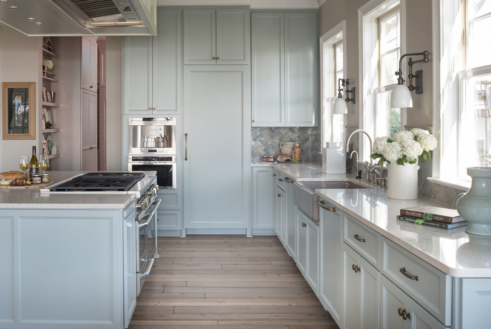 Esempio di una grande cucina tradizionale con lavello stile country, ante blu, top in marmo, paraspruzzi beige, elettrodomestici in acciaio inossidabile e parquet chiaro