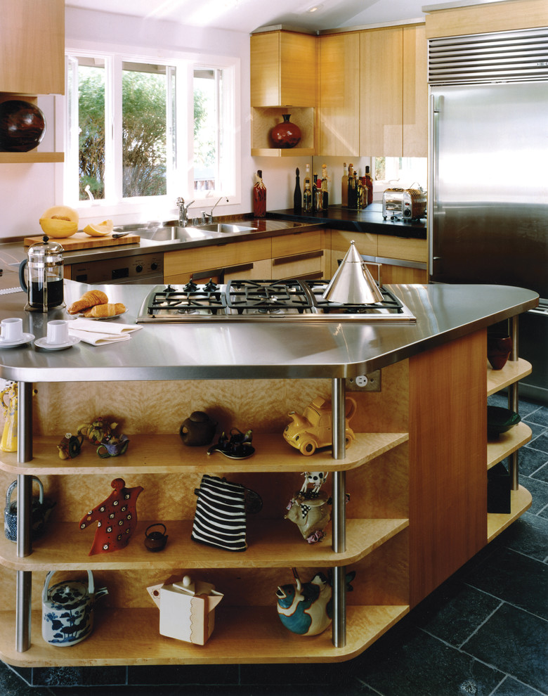 Inredning av ett modernt mellanstort u-kök, med en dubbel diskho, släta luckor, skåp i ljust trä, granitbänkskiva, rostfria vitvaror och marmorgolv
