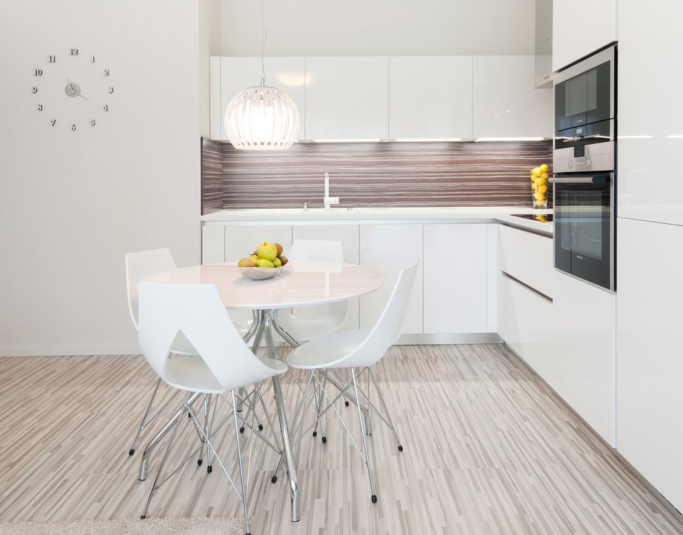 Moderne Wohnküche mit flächenbündigen Schrankfronten, weißen Schränken, Küchenrückwand in Braun und Küchengeräten aus Edelstahl in Sonstige