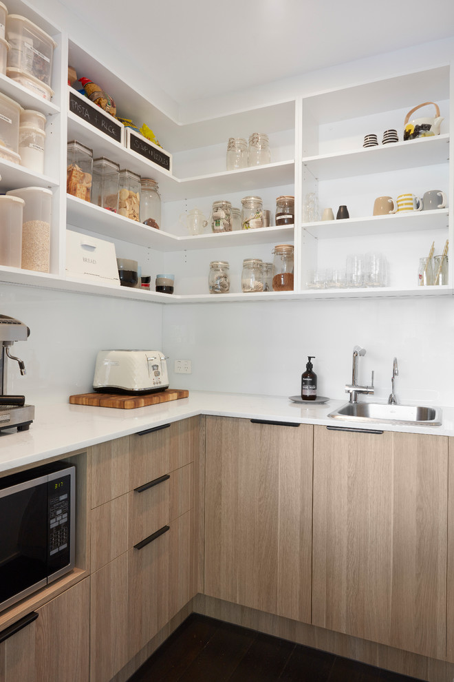 Large contemporary single-wall kitchen/diner in Melbourne with a double-bowl sink, open cabinets, white cabinets, white splashback, dark hardwood flooring, black floors and white worktops.