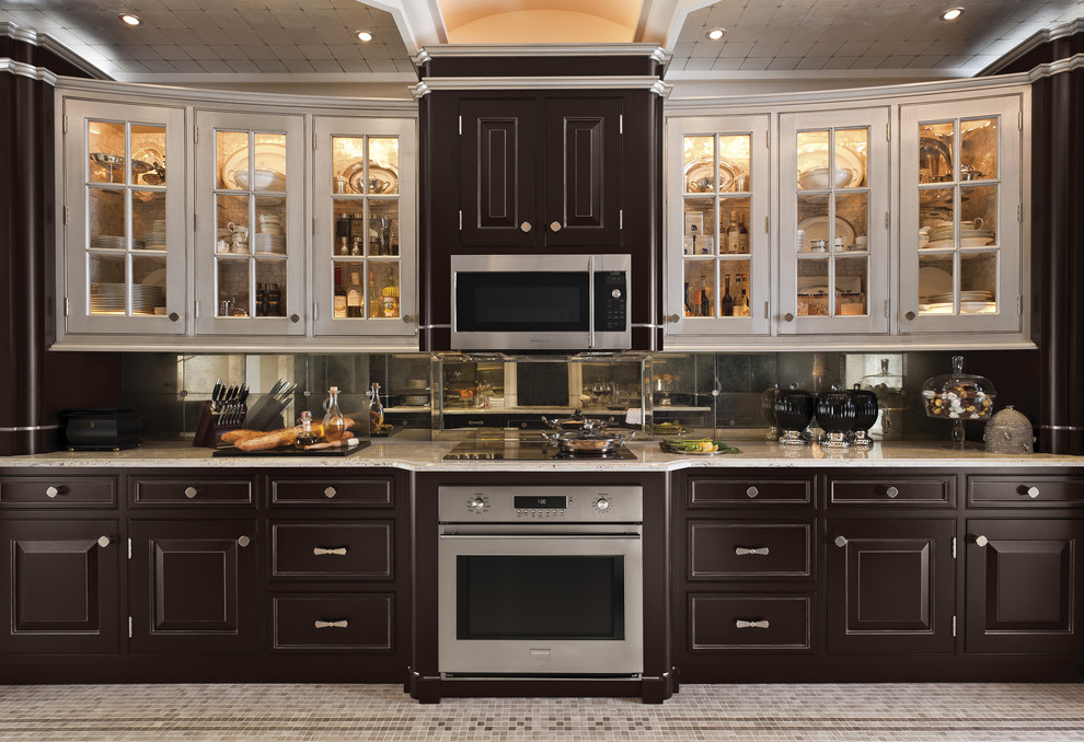 Medium sized classic u-shaped enclosed kitchen in Miami with raised-panel cabinets, dark wood cabinets, engineered stone countertops, mirror splashback, stainless steel appliances, porcelain flooring, no island and beige floors.