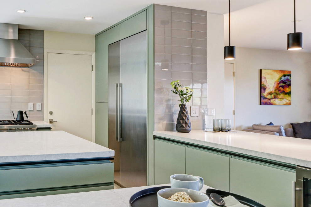 Medium sized contemporary u-shaped open plan kitchen in San Francisco with a submerged sink, flat-panel cabinets, green cabinets, engineered stone countertops, green splashback, ceramic splashback, stainless steel appliances, cement flooring, an island, beige floors and grey worktops.