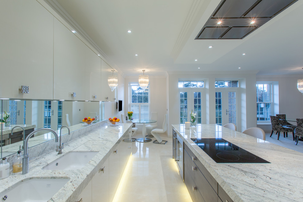 Idee per una cucina design di medie dimensioni con lavello da incasso, ante lisce, ante bianche, top in marmo, paraspruzzi a specchio, elettrodomestici in acciaio inossidabile e pavimento con piastrelle in ceramica