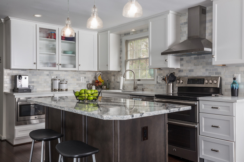 Example of a mid-sized transitional l-shaped dark wood floor and brown floor eat-in kitchen design in DC Metro with an undermount sink, shaker cabinets, white cabinets, quartz countertops, white backsplash, stone tile backsplash, stainless steel appliances and an island