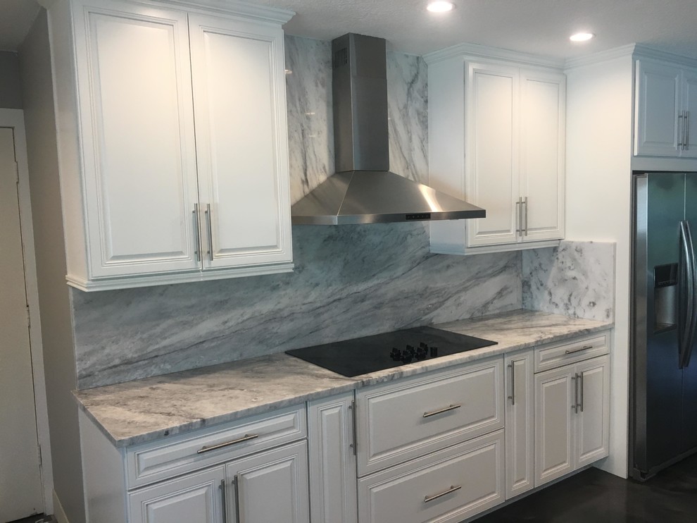 Immagine di una cucina moderna di medie dimensioni con lavello sottopiano, top in quarzite, paraspruzzi bianco, elettrodomestici in acciaio inossidabile, pavimento in cemento e pavimento grigio
