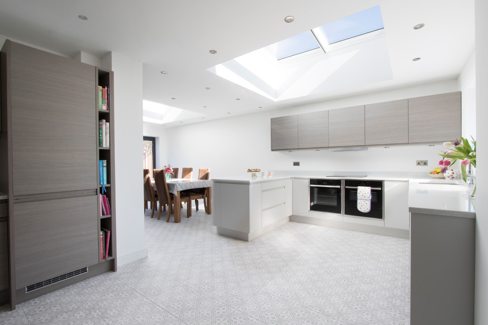 Large contemporary u-shaped kitchen/diner in Other with a submerged sink, quartz worktops, black appliances, porcelain flooring, multi-coloured floors and white worktops.