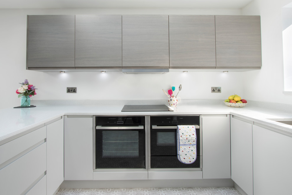 Foto di una grande cucina minimal con lavello sottopiano, top in quarzite, elettrodomestici neri, pavimento in gres porcellanato, pavimento multicolore e top bianco