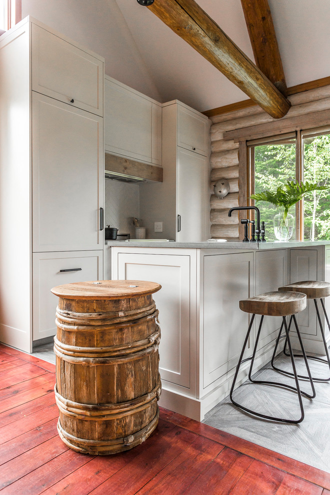 Eat-in kitchen - large rustic u-shaped porcelain tile and gray floor eat-in kitchen idea in Montreal with an undermount sink, shaker cabinets, concrete countertops, white backsplash, paneled appliances, an island, gray countertops, white cabinets and ceramic backsplash