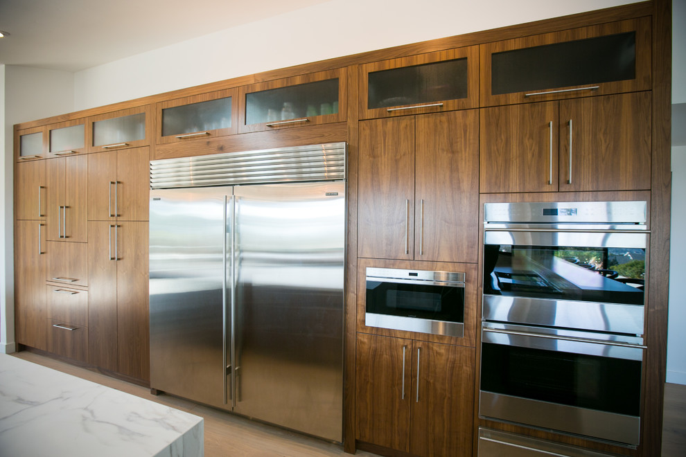 Foto di una grande cucina minimal con ante lisce, ante in legno scuro, top in superficie solida e paraspruzzi bianco