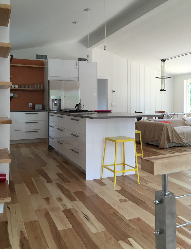 Foto de cocinas en L costera de tamaño medio abierta con armarios con paneles lisos, puertas de armario blancas y una isla
