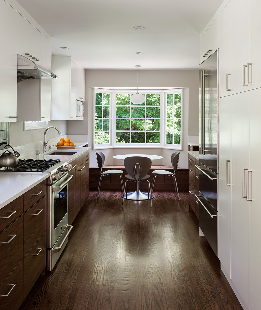 Trendy galley dark wood floor enclosed kitchen photo in San Francisco with flat-panel cabinets, dark wood cabinets, stainless steel appliances and no island