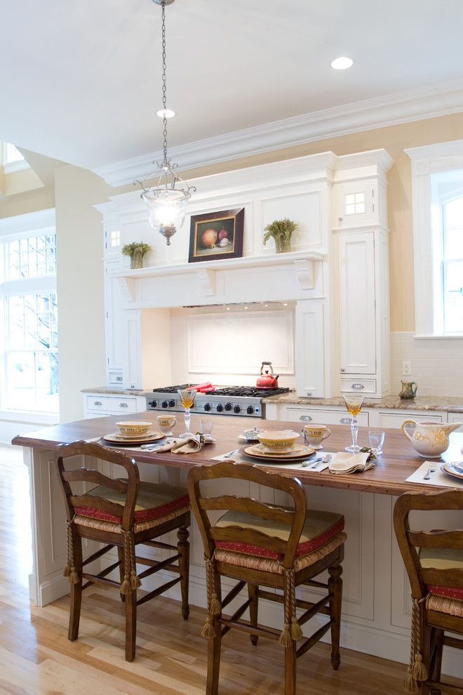 Foto di una cucina a L chic con lavello stile country, ante a filo, ante bianche e elettrodomestici da incasso