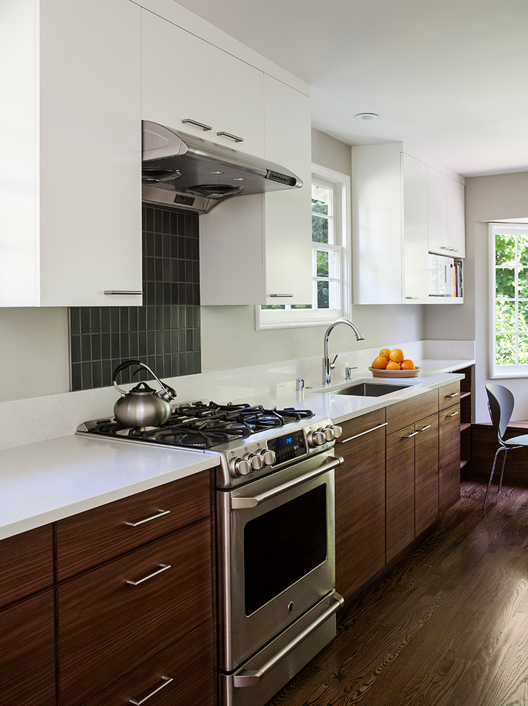 Inspiration for a mid-sized transitional u-shaped dark wood floor kitchen remodel in San Francisco with an undermount sink, flat-panel cabinets, dark wood cabinets, tile countertops, white backsplash, ceramic backsplash and stainless steel appliances