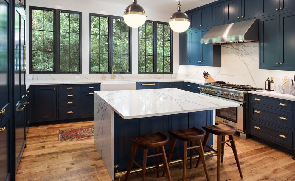 Exempel på ett stort klassiskt kök, med en rustik diskho, skåp i shakerstil, blå skåp, bänkskiva i kvarts, vitt stänkskydd, stänkskydd i sten, integrerade vitvaror, mellanmörkt trägolv och en köksö