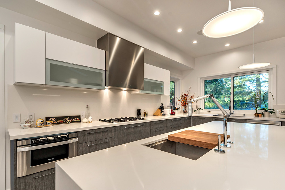 Inspiration for a large contemporary u-shaped open plan kitchen in San Francisco with a built-in sink, flat-panel cabinets, dark wood cabinets, engineered stone countertops, white splashback, stainless steel appliances, an island, ceramic flooring and grey floors.