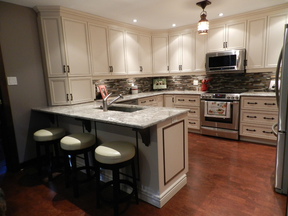 Exempel på ett mellanstort, avskilt klassiskt grå grått u-kök, med en undermonterad diskho, granitbänkskiva, stänkskydd i glaskakel, rostfria vitvaror, mörkt trägolv, luckor med infälld panel, vita skåp, flerfärgad stänkskydd, en halv köksö och brunt golv