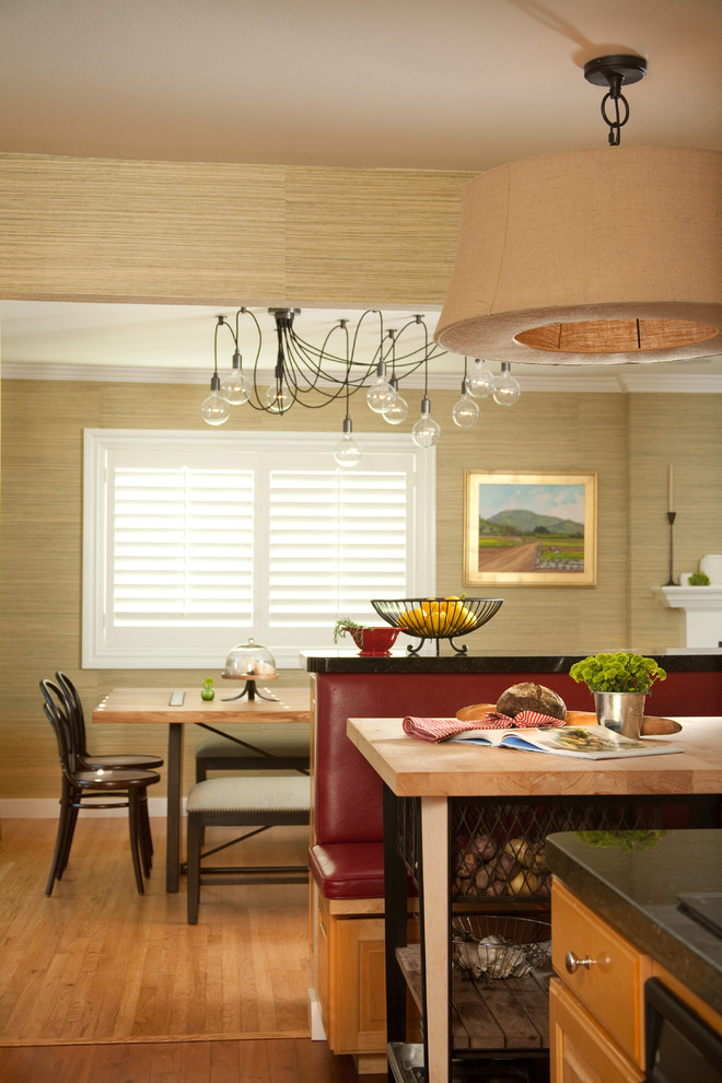 На фото: кухня в стиле фьюжн с обеденным столом, фасадами цвета дерева среднего тона, паркетным полом среднего тона, островом и обоями на стенах