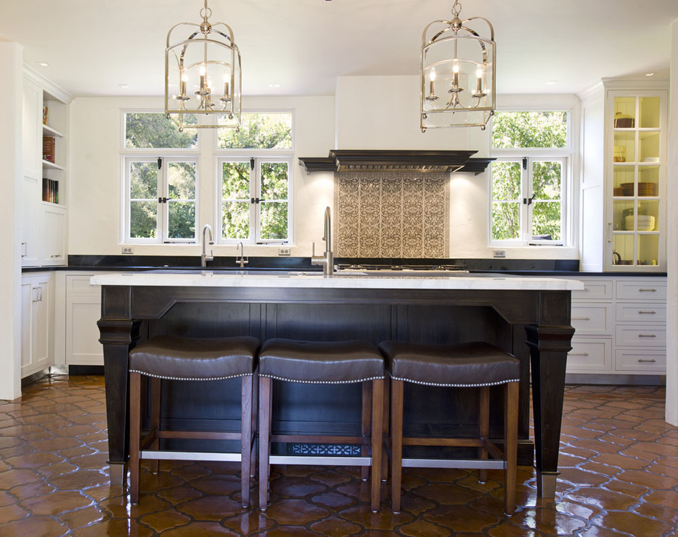 Mediterranean kitchen in Santa Barbara with recessed-panel cabinets and white cabinets.