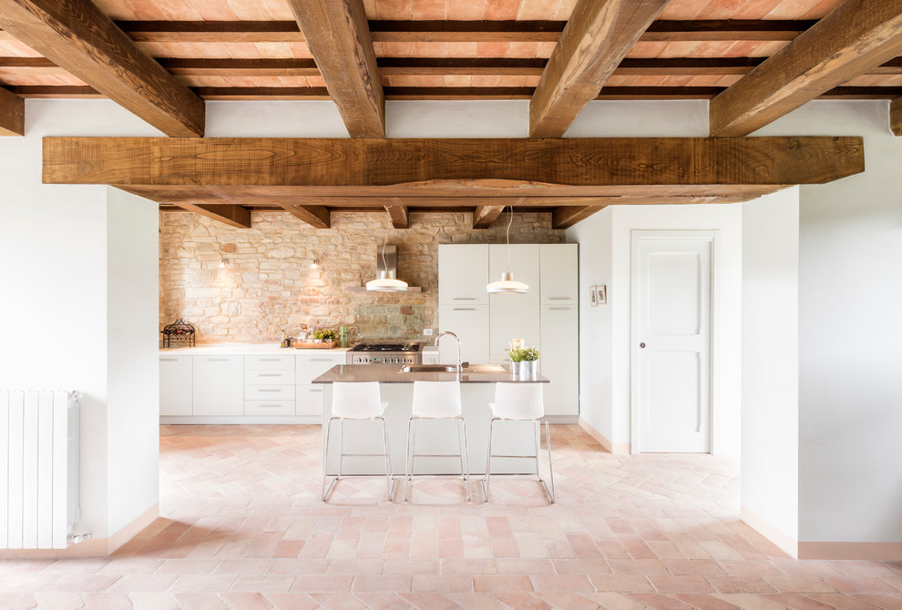 Immagine di una grande cucina minimalista con ante lisce, ante bianche, pavimento in terracotta, lavello a doppia vasca e elettrodomestici in acciaio inossidabile