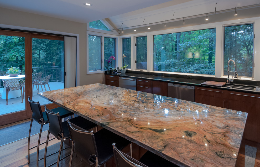 Example of a huge trendy l-shaped medium tone wood floor eat-in kitchen design in DC Metro with an undermount sink, flat-panel cabinets, medium tone wood cabinets, granite countertops, black backsplash, stone slab backsplash, stainless steel appliances and an island