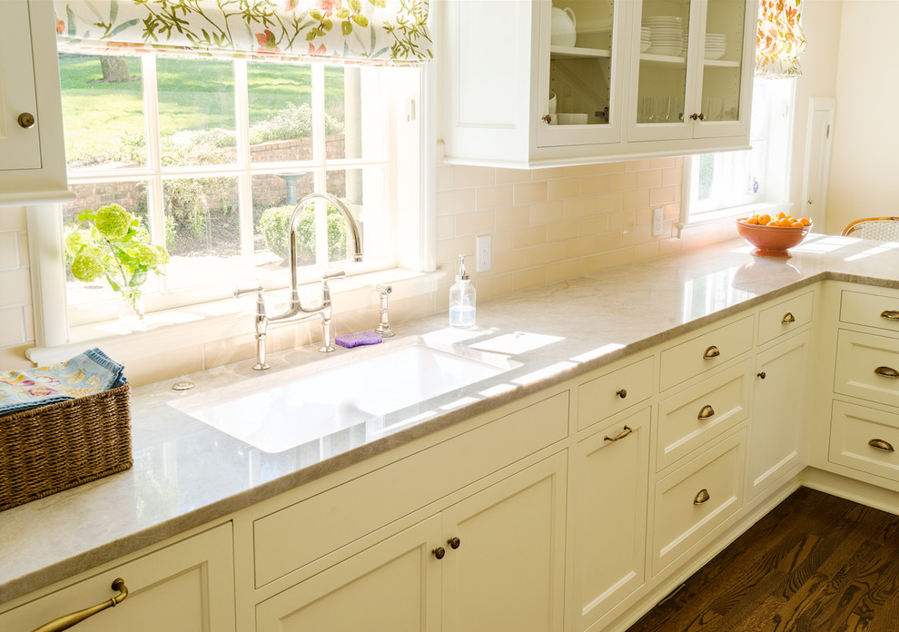 Medium sized classic u-shaped kitchen pantry in Portland with a double-bowl sink, shaker cabinets, white cabinets, composite countertops, beige splashback, porcelain splashback, white appliances and dark hardwood flooring.