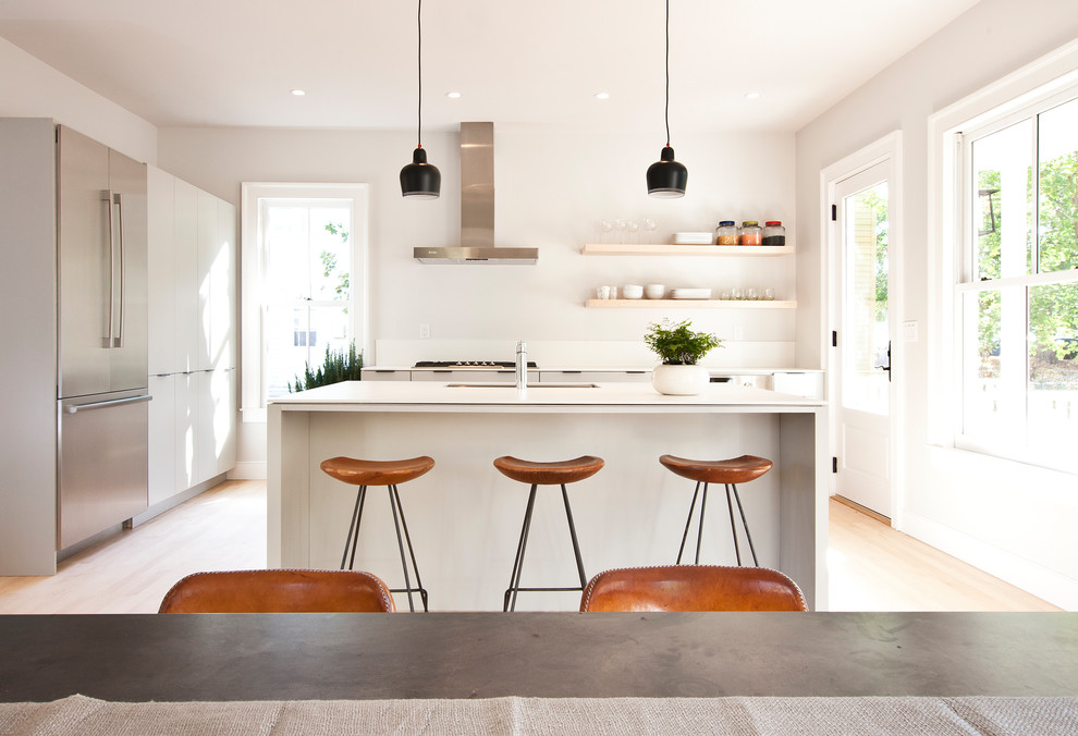 Mid-sized minimalist l-shaped light wood floor and beige floor eat-in kitchen photo in New York with an undermount sink, flat-panel cabinets, white cabinets, quartz countertops, stainless steel appliances, an island and white countertops