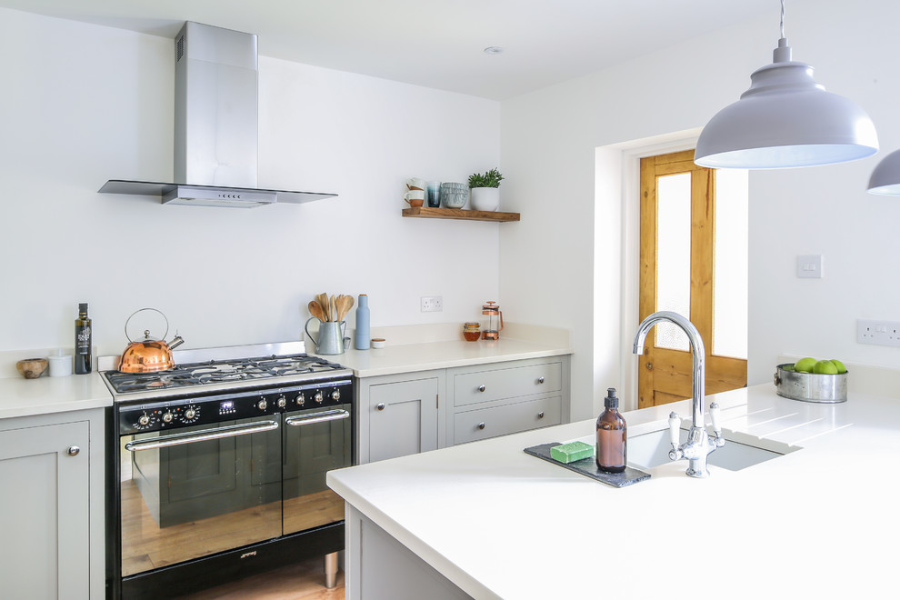 Immagine di una piccola cucina minimal con lavello sottopiano, ante in stile shaker, ante grigie, top in quarzite, elettrodomestici neri, parquet chiaro e pavimento marrone