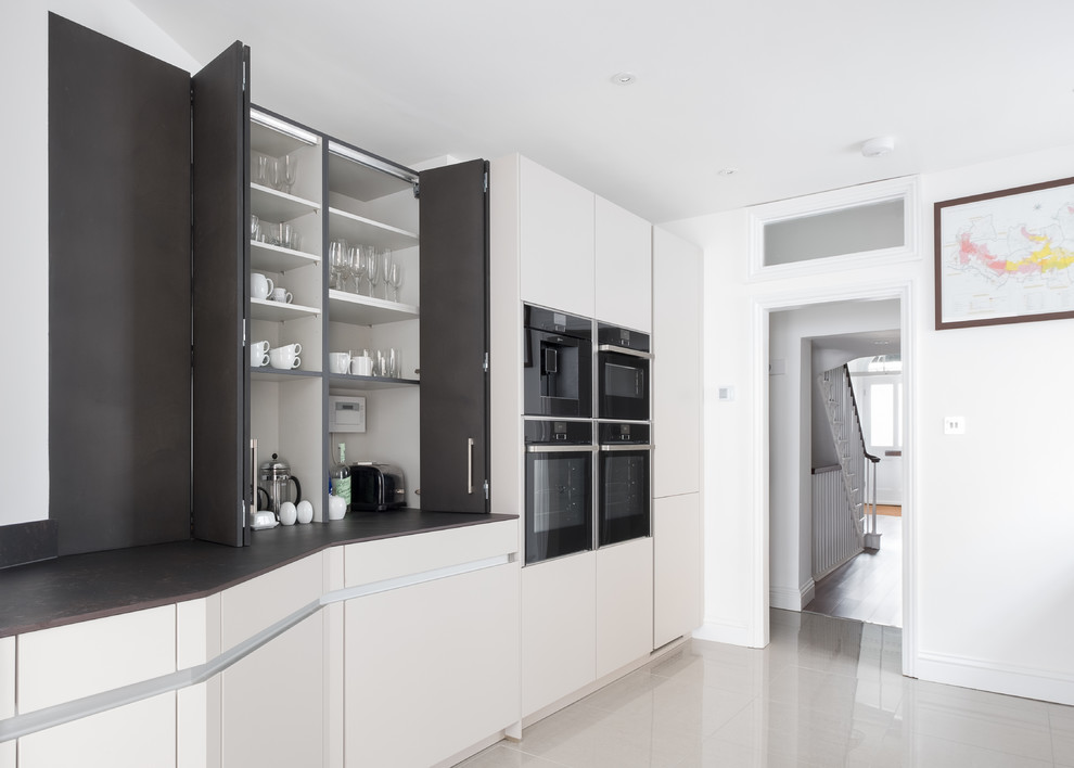 Exempel på ett mellanstort modernt kök, med en nedsänkt diskho, släta luckor, grå skåp, bänkskiva i koppar, grått stänkskydd, svarta vitvaror, klinkergolv i porslin och beiget golv