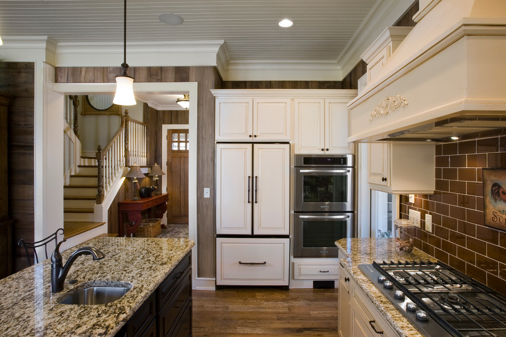 Eat-in kitchen - mid-sized rustic single-wall light wood floor eat-in kitchen idea in Other with an integrated sink, beaded inset cabinets, white cabinets, granite countertops, red backsplash, ceramic backsplash, white appliances and an island