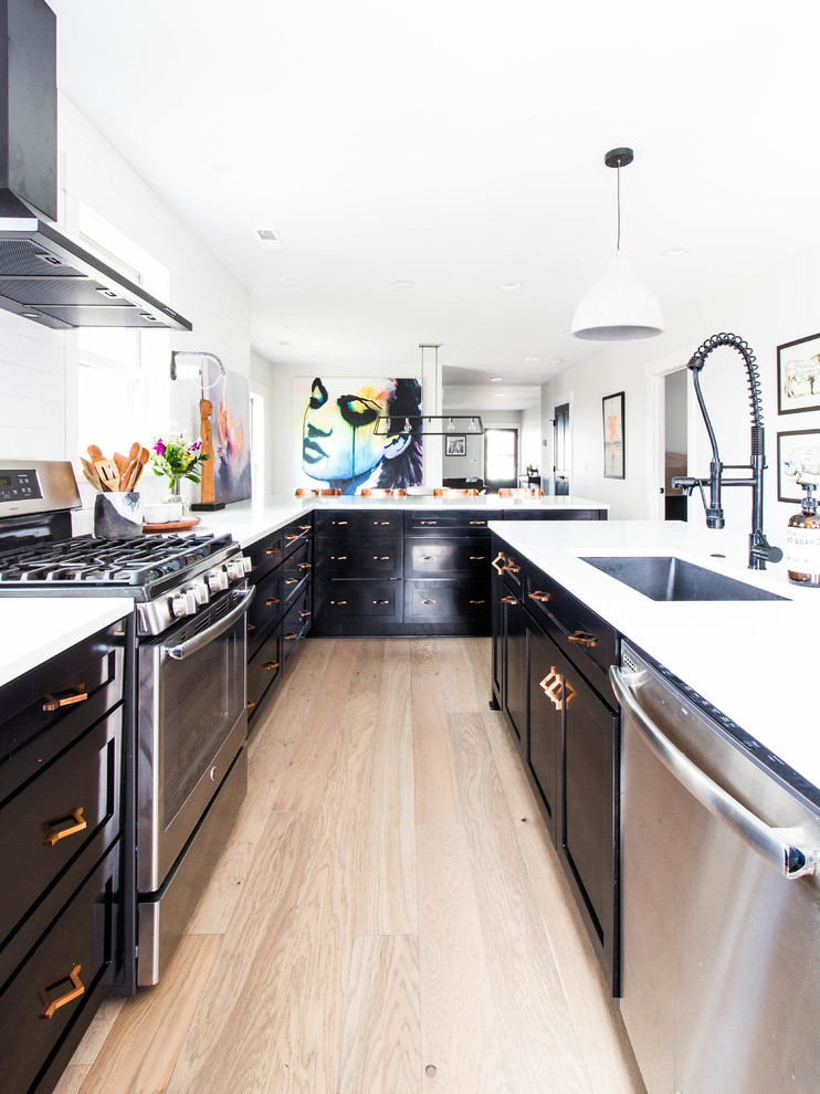 Inspiration for a contemporary l-shaped light wood floor and beige floor kitchen remodel in Nashville with an undermount sink, shaker cabinets, black cabinets, stainless steel appliances, an island and white countertops