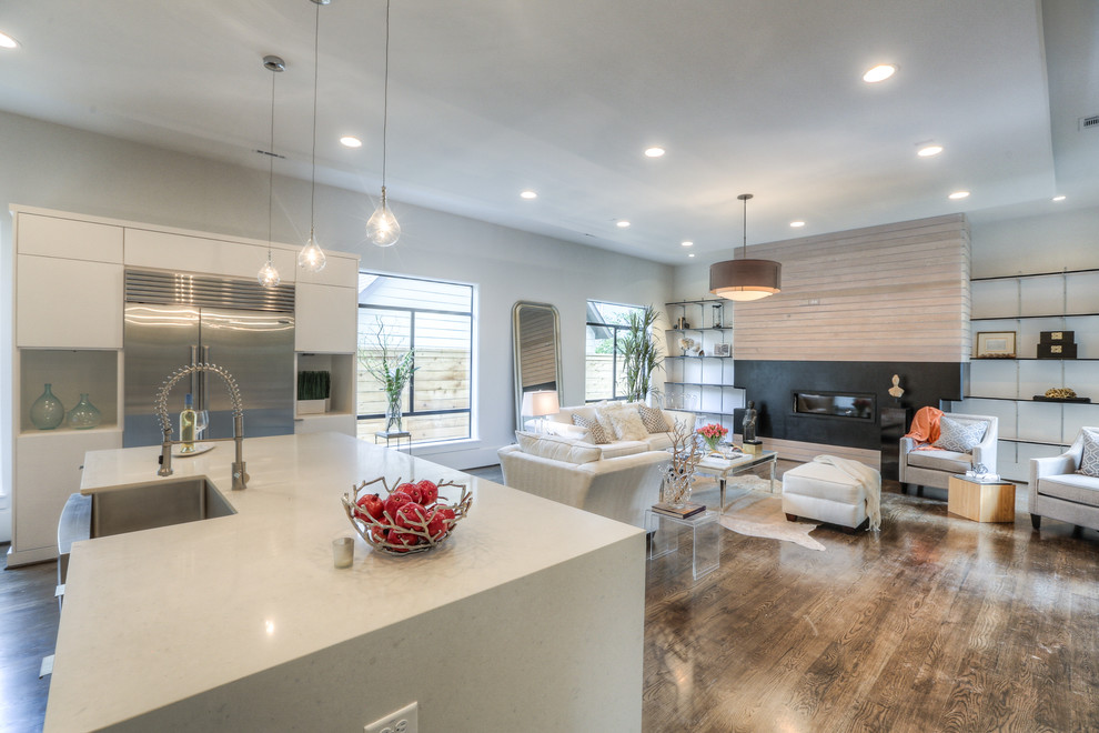 Large trendy u-shaped medium tone wood floor and brown floor eat-in kitchen photo in Houston with a farmhouse sink, flat-panel cabinets, white cabinets, quartz countertops, blue backsplash, glass tile backsplash, stainless steel appliances, an island and white countertops