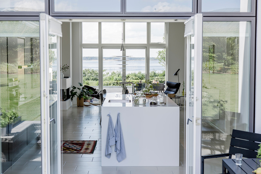 Imagen de cocina escandinava de tamaño medio con puertas de armario blancas y una isla