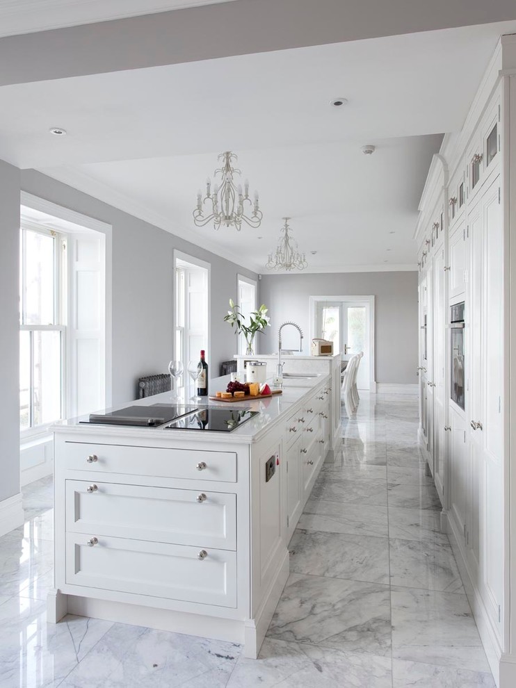 Inredning av ett klassiskt kök och matrum, med vita skåp, marmorbänkskiva, marmorgolv, en köksö och vitt golv