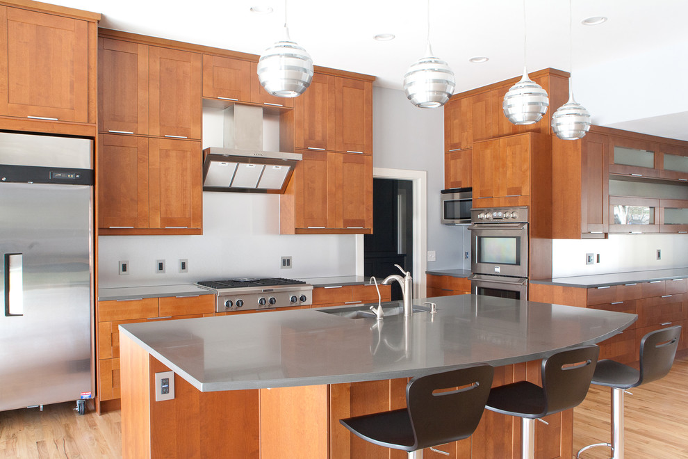 Foto på ett stort funkis linjärt kök och matrum, med skåp i shakerstil, skåp i mellenmörkt trä, rostfria vitvaror, en dubbel diskho, bänkskiva i zink, vitt stänkskydd, mellanmörkt trägolv, en köksö och brunt golv