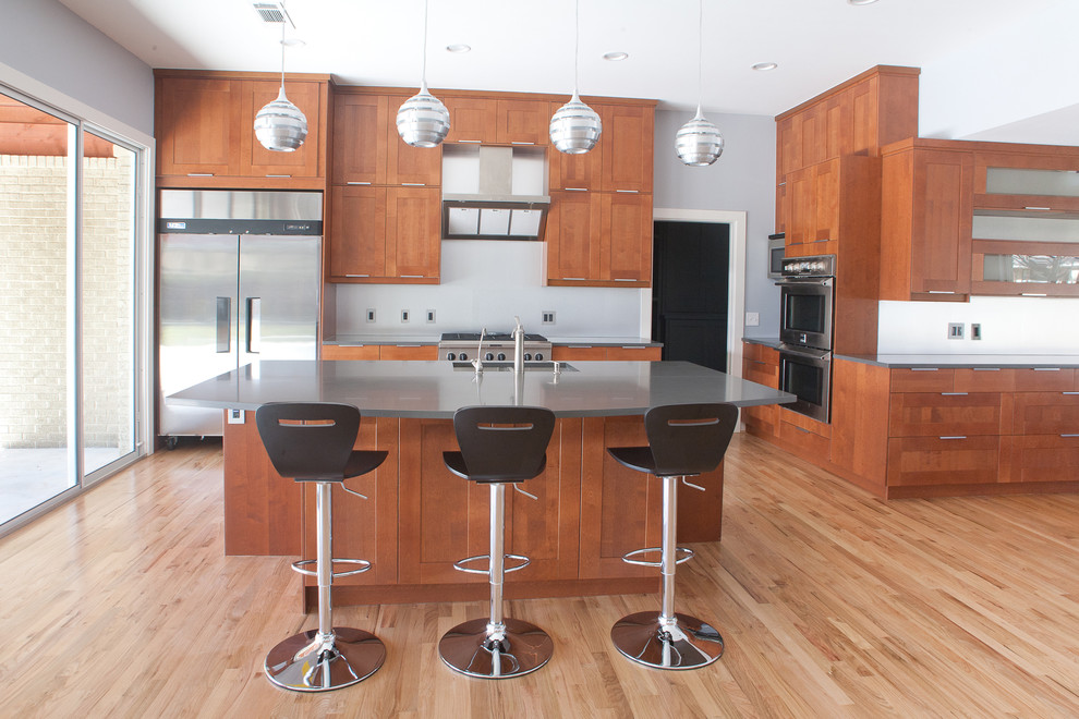 Large minimalist single-wall medium tone wood floor and brown floor eat-in kitchen photo in Dallas with a double-bowl sink, shaker cabinets, medium tone wood cabinets, zinc countertops, white backsplash, stainless steel appliances and an island